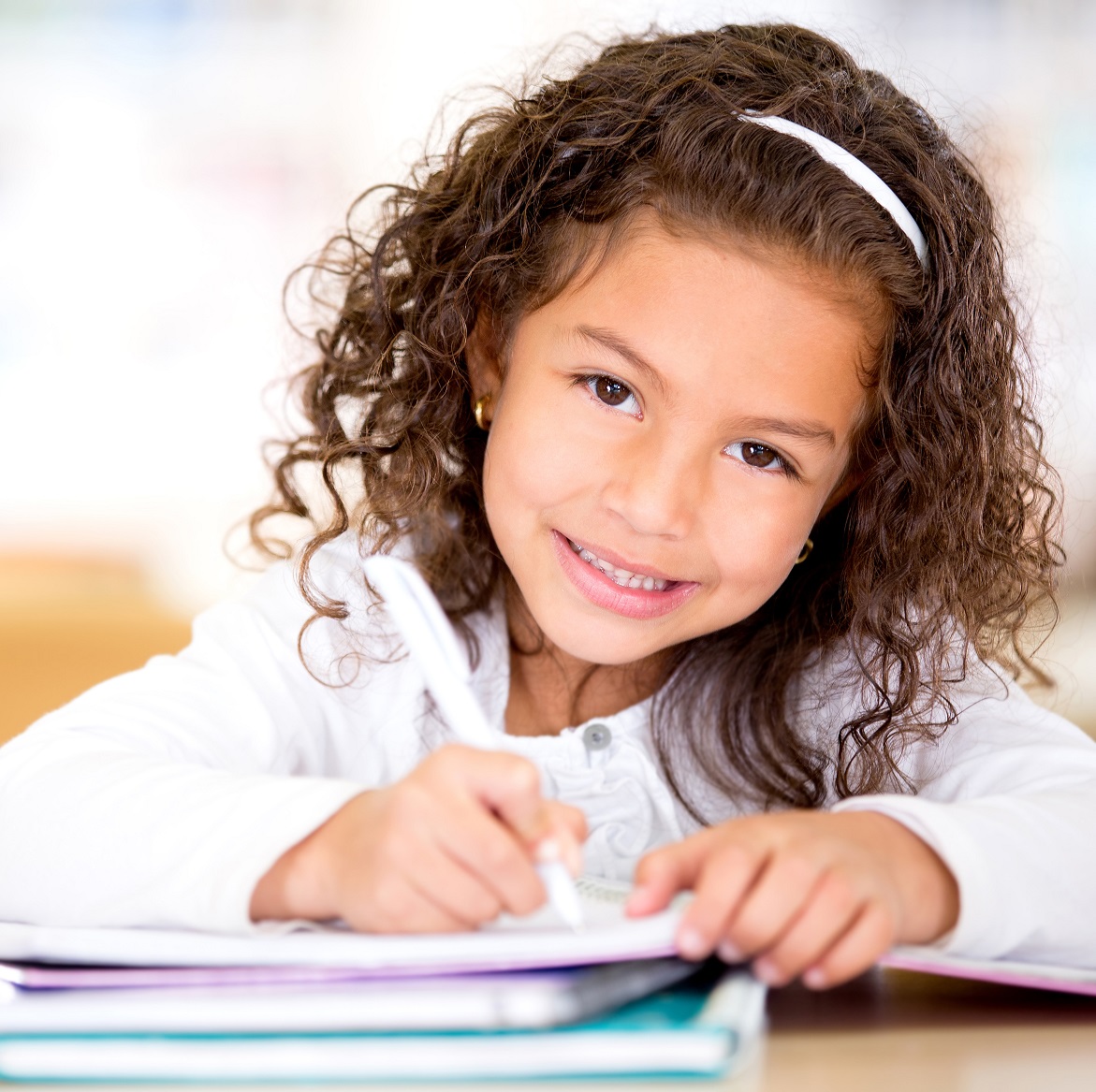 Cute,Little,Girl,Studying,At,The,Library,And,Smiling